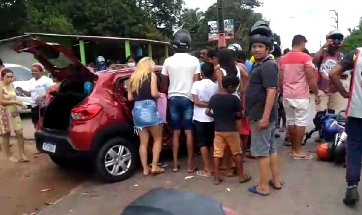 Pessoas tentam socorrer vítimas no carro