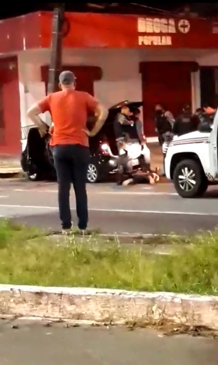 Policias imobilizam suspeitos, vítima está no canteiro central de camisa laranja