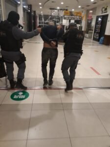 Suspeito sendo encaminhado à delegacia de Polícia